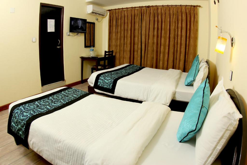 um quarto de hotel com duas camas e uma janela em Bag Packer's Lodge em Catmandu