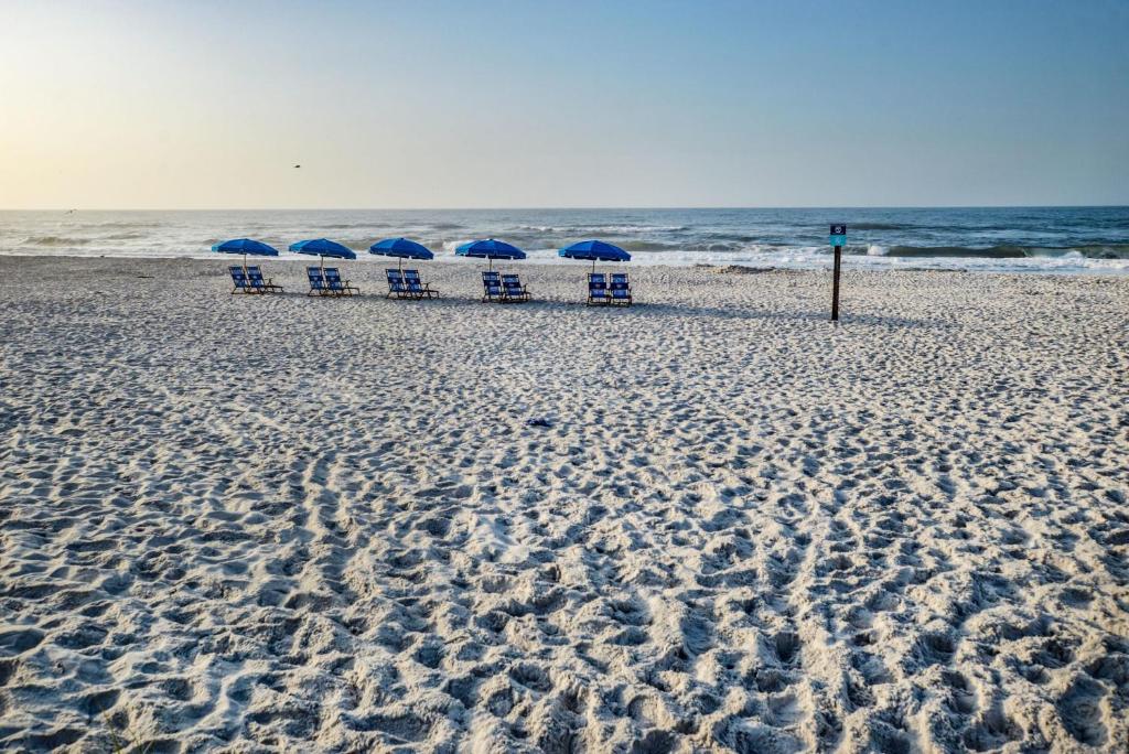 uma praia com cadeiras e guarda-sóis na areia em Beautiful Views And Just Steps To The Beach - #38 Sleeps 7 em Gulf Shores