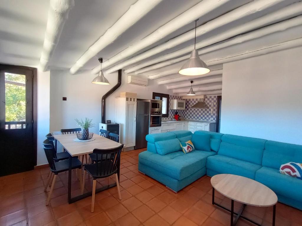 ein Wohnzimmer mit einem blauen Sofa und einem Tisch in der Unterkunft Sésamo Apartamento in Hervás