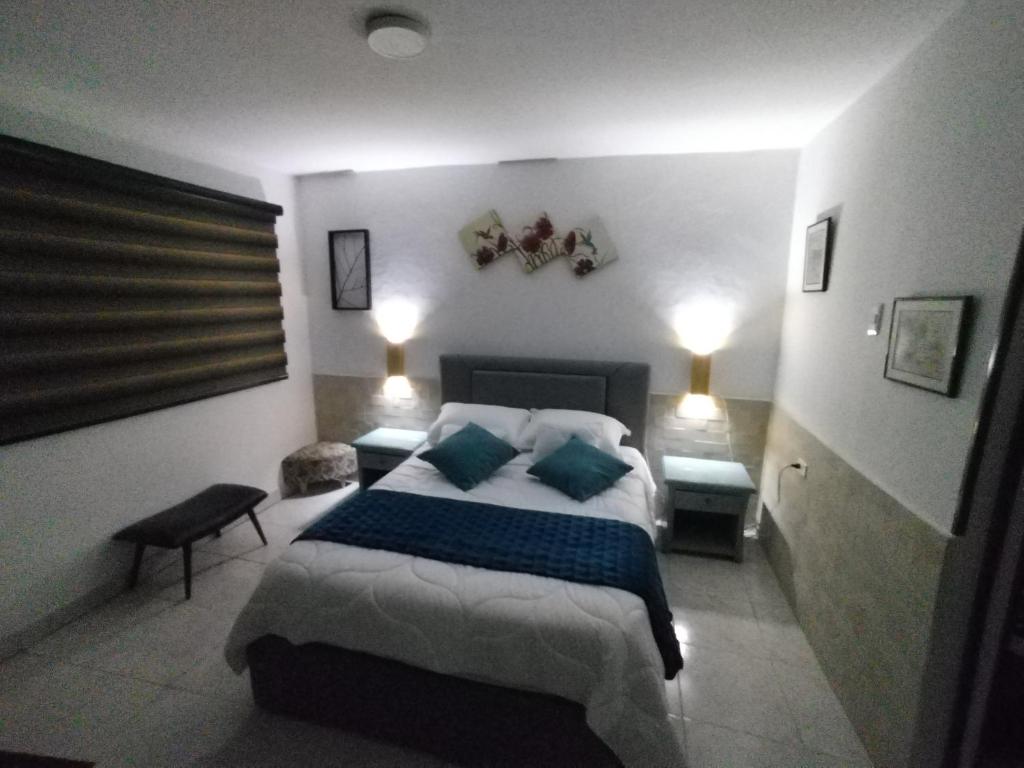 a bedroom with a large bed with blue pillows at Hospedaje Estrella de Luna in Bogotá