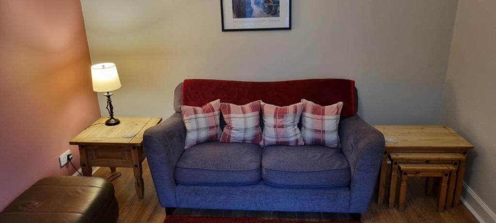 niebieski fotel z dwoma poduszkami w pokoju w obiekcie Millhill St Dunfermline w mieście Dunfermline