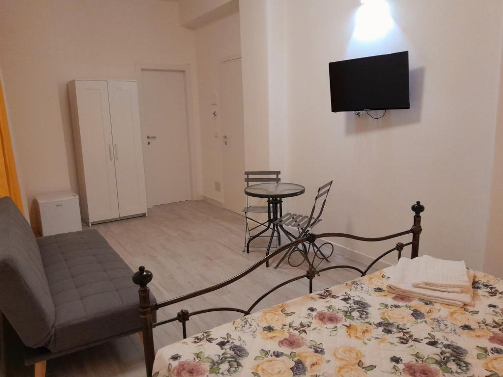 a bedroom with a bed and a chair and a television at La Stazione 92 in Catania