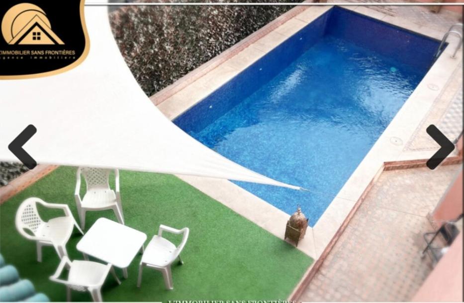 een man die naast een zwembad met stoelen staat bij Authentic Targa Villa with a Private Pool No overlooking in Marrakesh