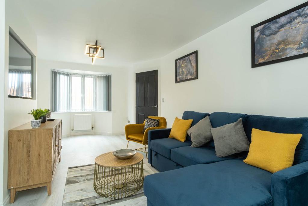 ein Wohnzimmer mit einem blauen Sofa und gelben Kissen in der Unterkunft Luxury Executive Home in Birmingham in Birmingham