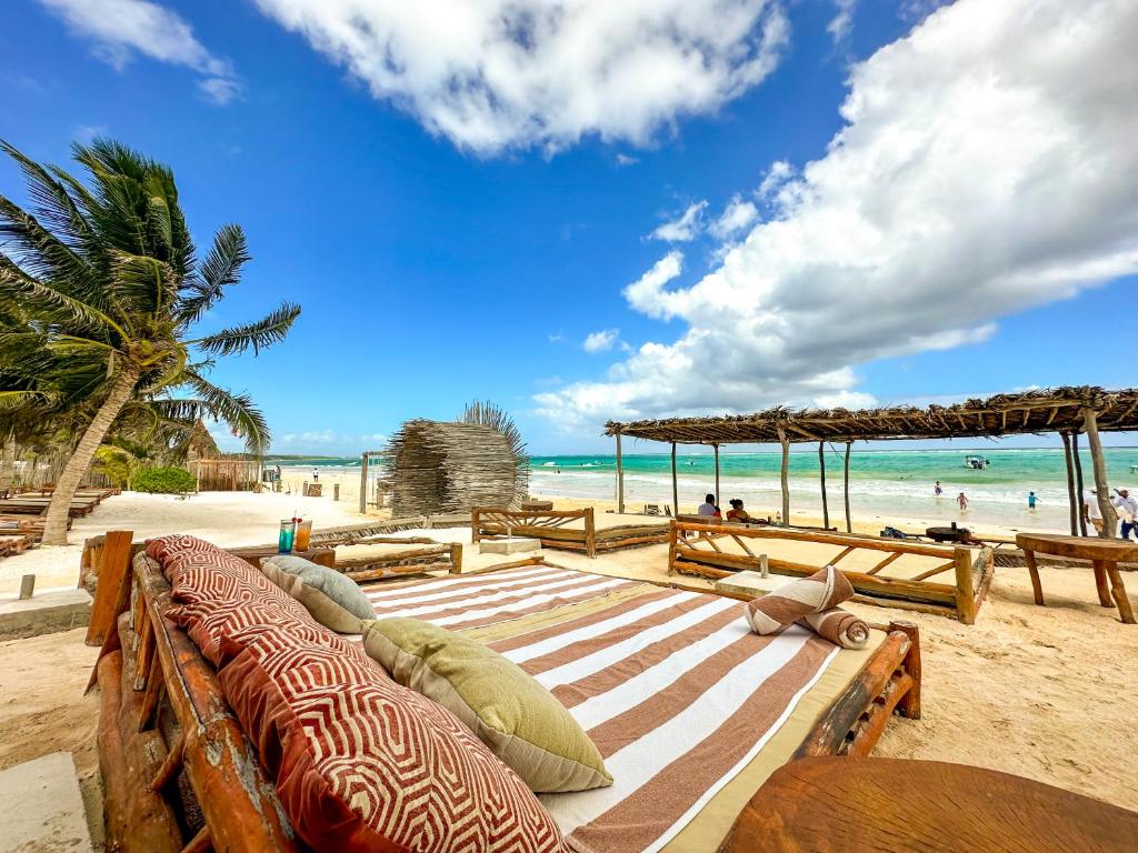 a beach with benches and a view of the ocean at Alito Tulum Hotel in Tulum