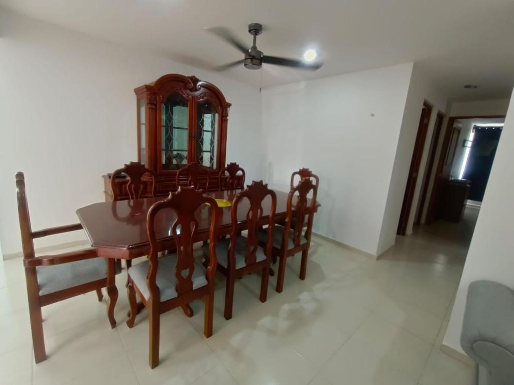 ein Esszimmer mit einem Holztisch und Stühlen in der Unterkunft Casa de 3 recamaras frente al parque in Mérida