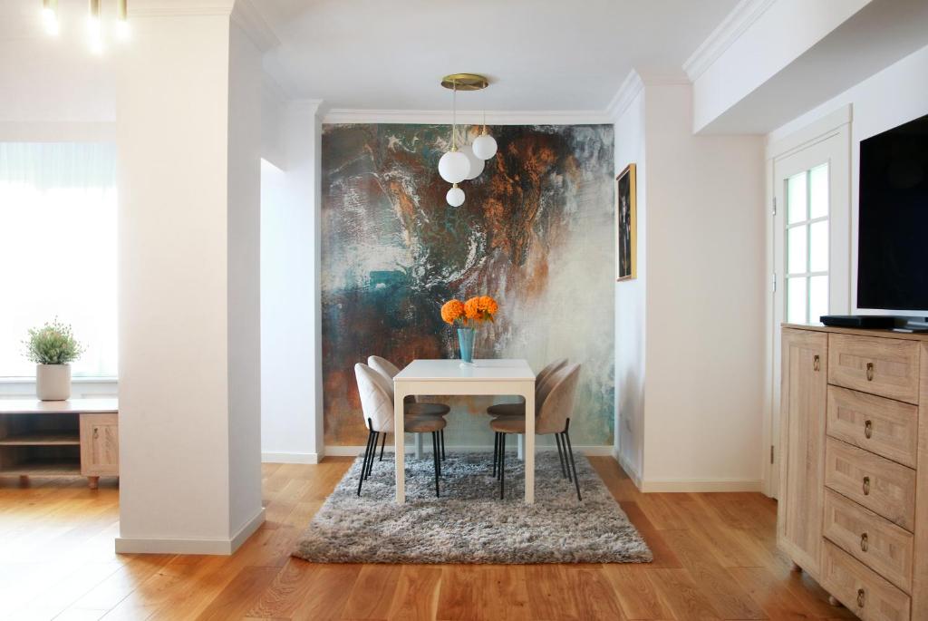 una sala da pranzo con tavolo e un dipinto sul muro di Premium Central Apartment a Braşov