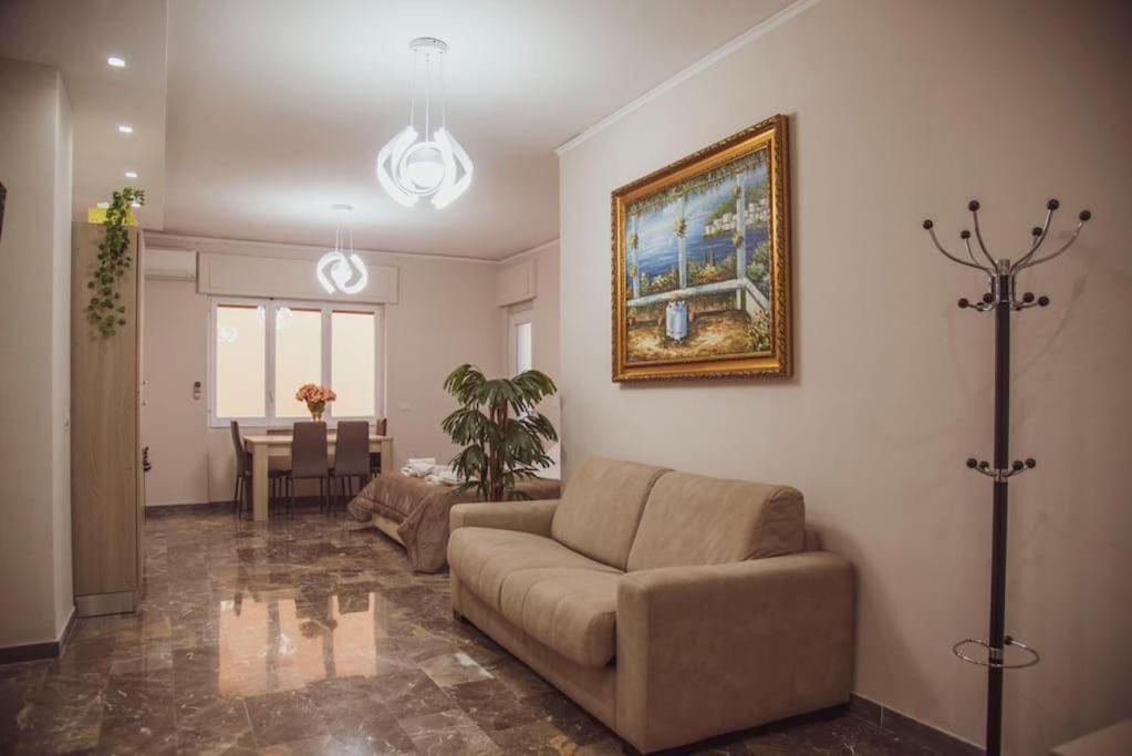 a living room with a couch and a painting on the wall at Campania Apartment Pompei Luxury - 150m dalla stazione - 5km da Pompei in Poggiomarino