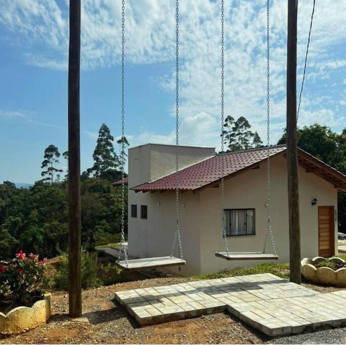une petite maison avec une balançoire en face dans l'établissement Lake House_SC, à Rio Forcação