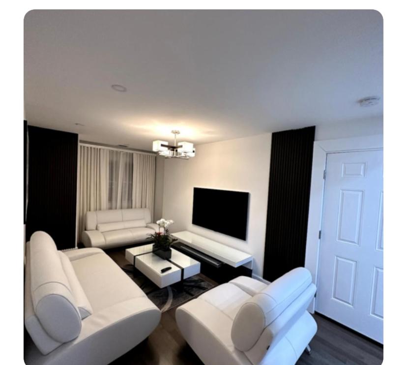 ein Wohnzimmer mit weißen Möbeln und einem Flachbild-TV in der Unterkunft Relaxing apartment in Massapequa