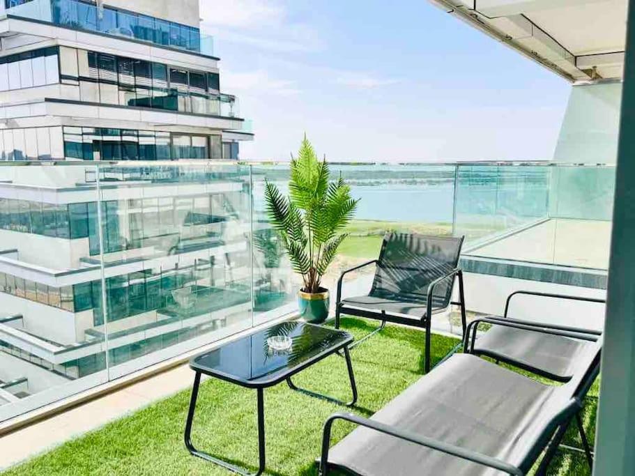 a balcony with two chairs and a table at Mayan Studio Apartment in Abu Dhabi