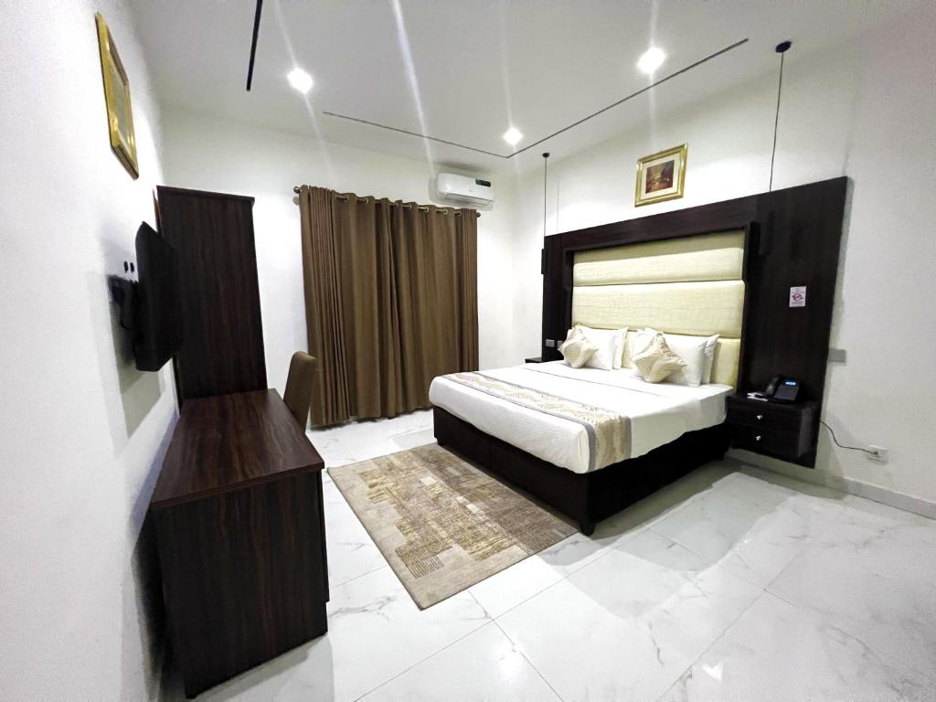 um quarto com uma cama e uma televisão em Riviera Hotel, Apartments & Resorts em Lekki