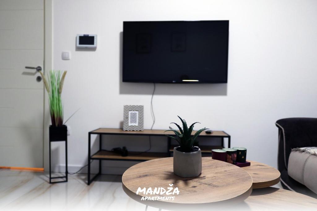 a living room with a table and a flat screen tv at Mandza in Novi Pazar