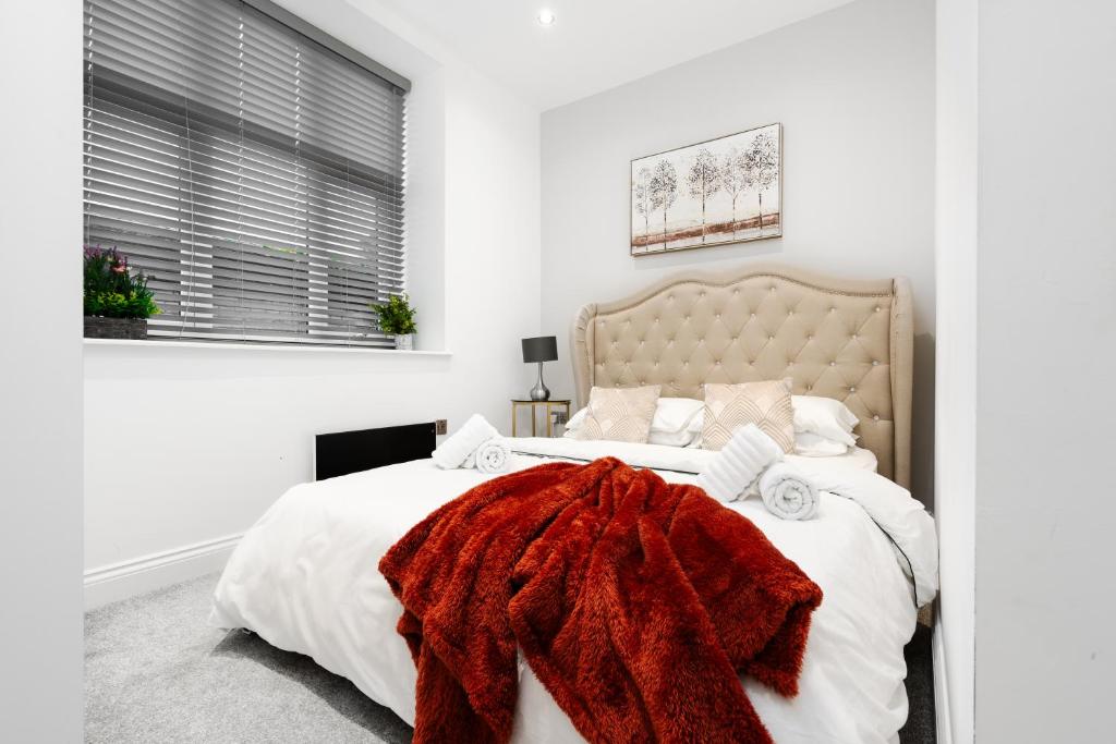 Un dormitorio con una cama con una manta roja. en The calm apartment with 2 ensuite bedrooms. en Preston