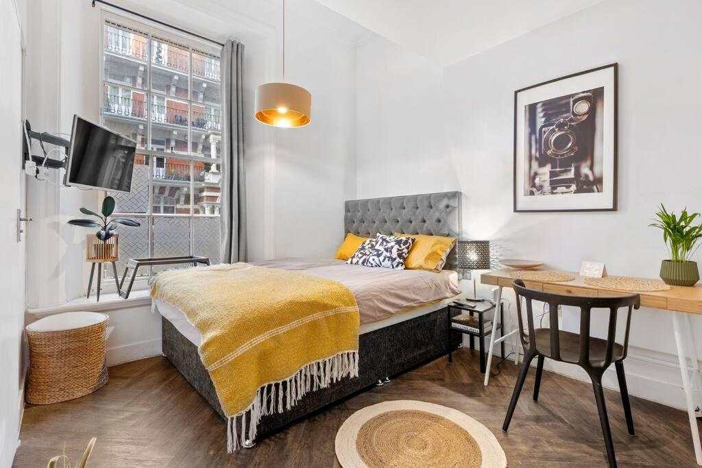 a bedroom with a bed and a desk and a table at Small studio in Central London Pay Straight Away to the host in London