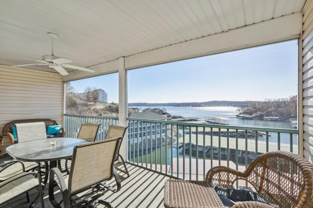 uma varanda com mesa e cadeiras e vista para a água em Lake Ozark Condo with Screened Balcony and Lake Views! em Lake Ozark