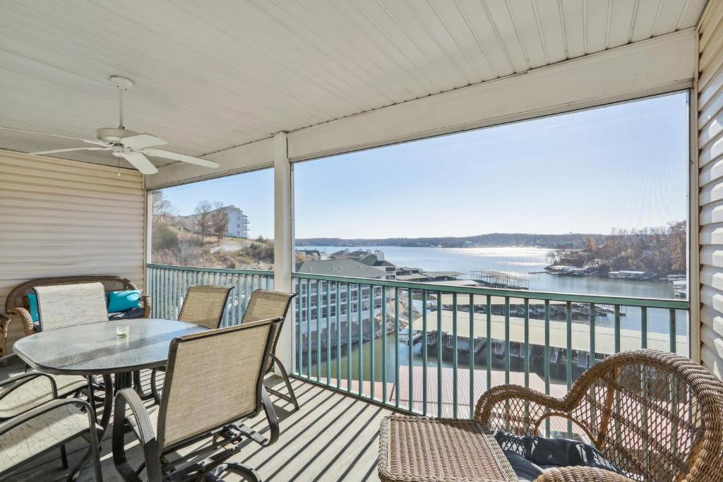 a balcony with a table and chairs and a view of the water at Condo with Balcony and Views in Lake of the Ozarks in Lake Ozark