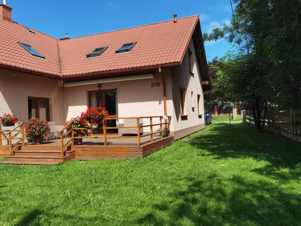 een huis met een houten terras en een tuin bij Akacja Apartament in Rzeszów