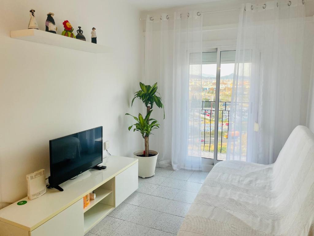 a white living room with a television and a couch at Barca 1 in Barcelona