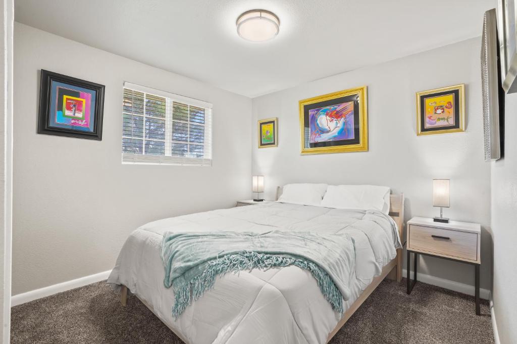 ein weißes Schlafzimmer mit einem Bett und zwei Nachttischen in der Unterkunft South Boise, Gathering Place Sleeps 16, Large Yard in Boise