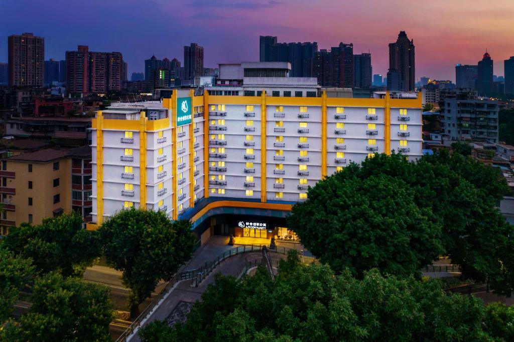 ein großes gelbes Gebäude mit einer Stadt im Hintergrund in der Unterkunft LNCommunity Guangzhou Haizhu Branch in Guangzhou