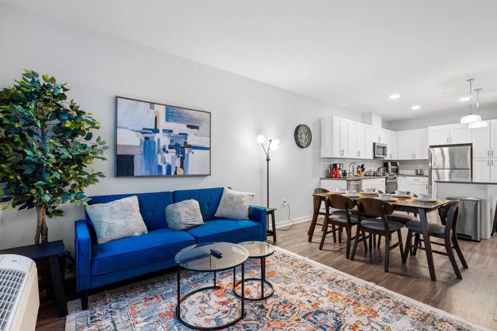 uma sala de estar com um sofá azul e uma mesa em Urban Elegance: 20 Minutes to NYC (Gym, Laundry) em Jersey City