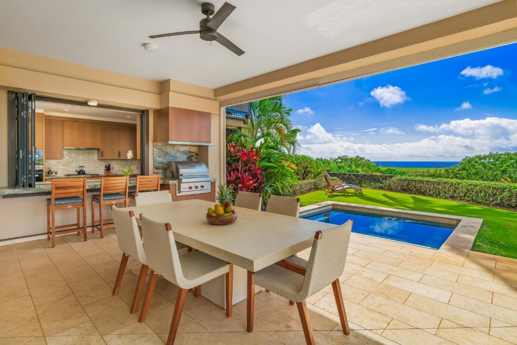 a kitchen and dining room with a view of the ocean at 2 BR Luxury Oceanview Condo in Kukuiula in Koloa