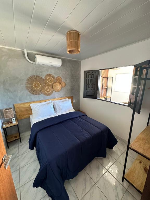 una camera da letto con un letto blu e una finestra di Casa da Praia Japaratinga a Japaratinga