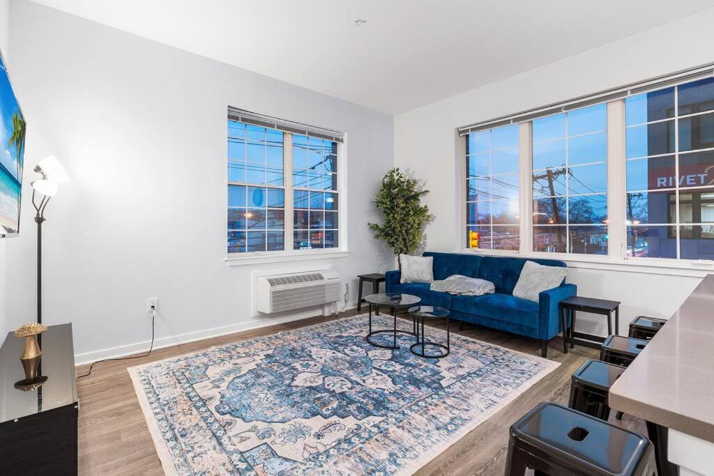 a living room with a blue couch and a rug at Urban Luxury Condo: 20 Mins to NYC (Gym, Laundry) in Jersey City