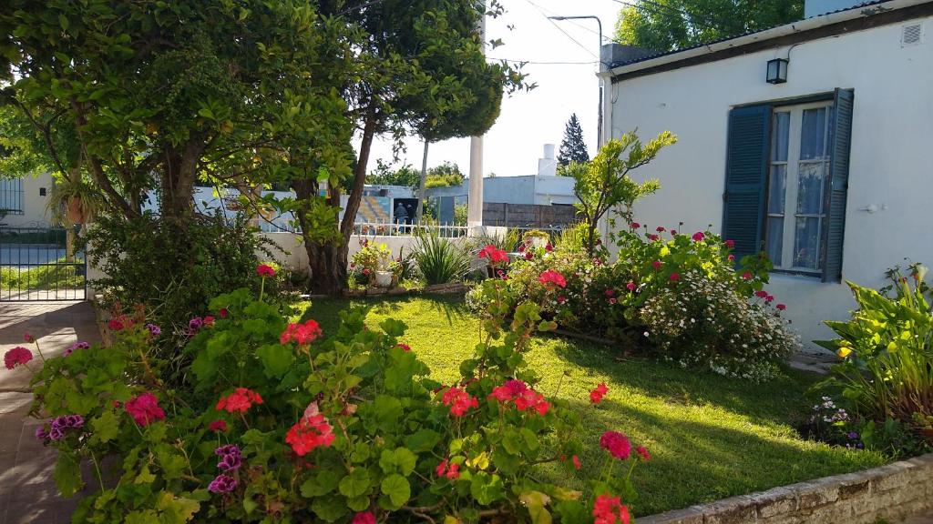 a garden with flowers and plants in front of a house at Casa familiar cerca de las termas in Dolores