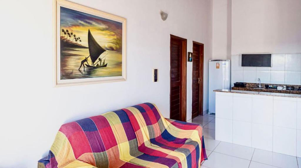 una sala de estar con sofá y una pintura en la pared en Casa da Juma, en Fortim