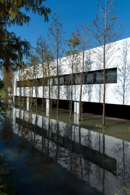 a white building with trees in the water at Good Stand in Suao