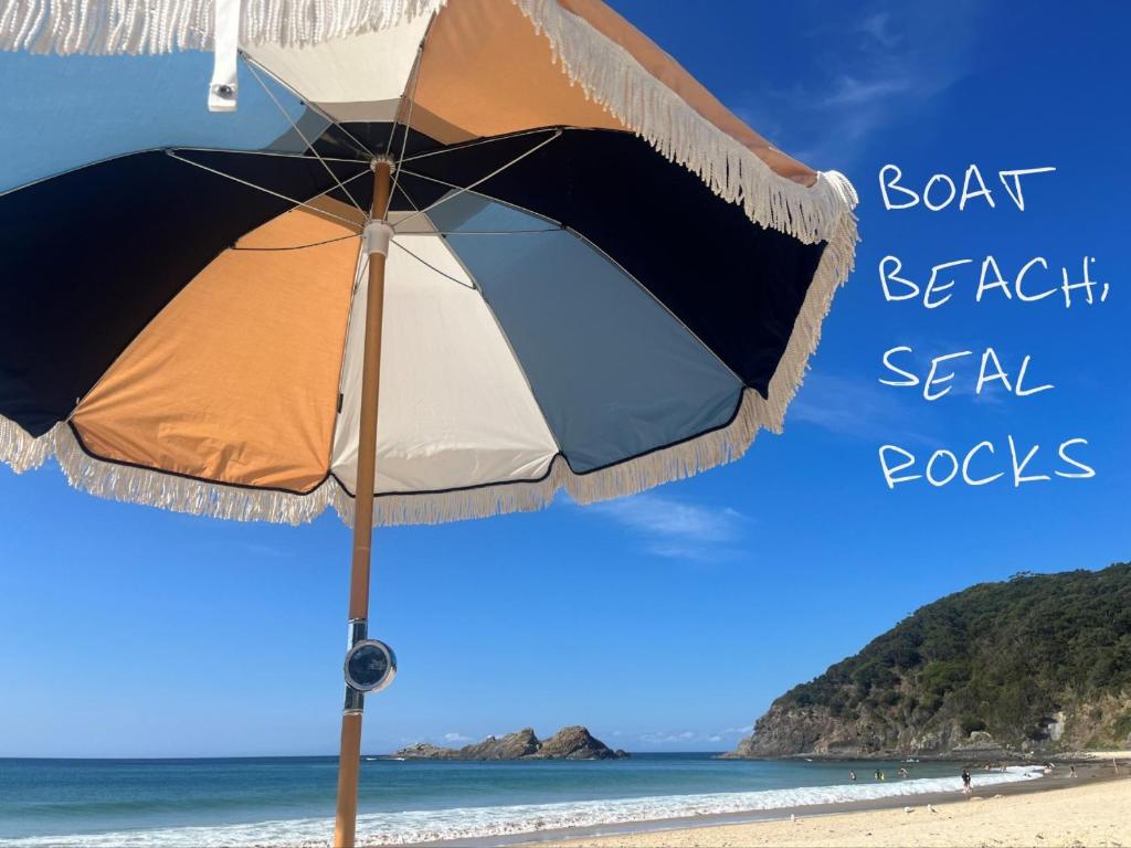 parasol na plaży ze słowami łódź plażowe skały morskie w obiekcie THE MAINSTAY Farmstay - book one of 4 houses or all 4, minutes to Seal Rocks! w mieście Neranie