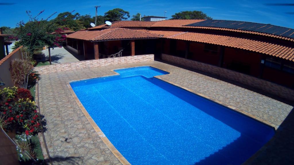 una gran piscina azul junto a una casa en Chácara Bella Vida com Piscina Churrasqueira Salão de Festas Fogão a Lenha Quadra, en Araçariguama
