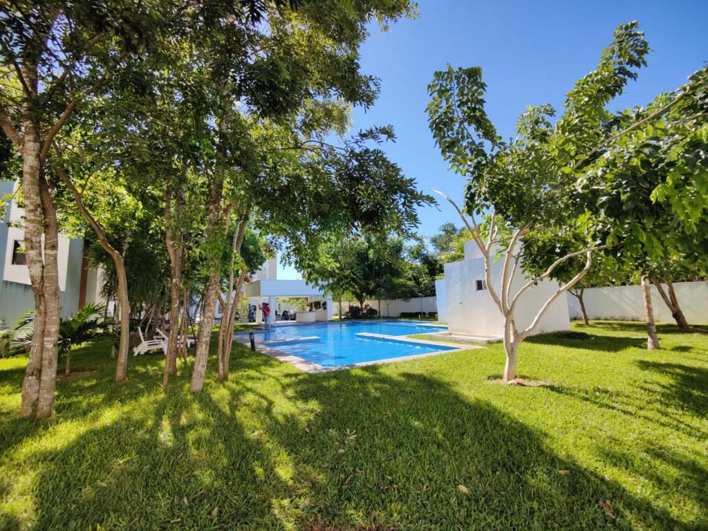 an image of a swimming pool in a yard with trees at DEPARTAMENTO PASEOS DE XCACEL in Playa del Carmen