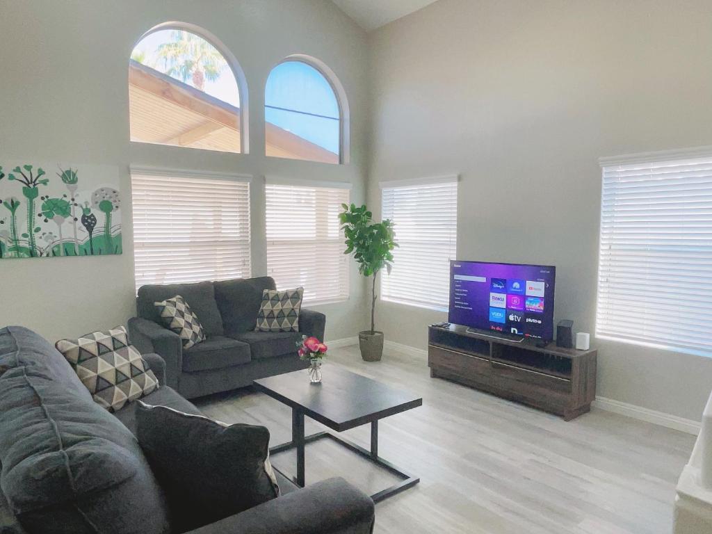 a living room with a couch and a tv at Pool House Newly Remodeled 3bed 3bath Near DT Summerlin and Red Rock in Las Vegas