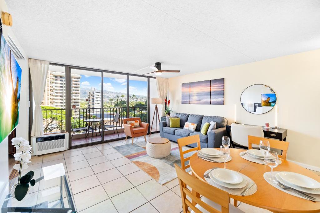 uma sala de estar com uma mesa e um sofá em Cozy Waikiki Getaway, Stroll to Beach with Free Parking em Honolulu