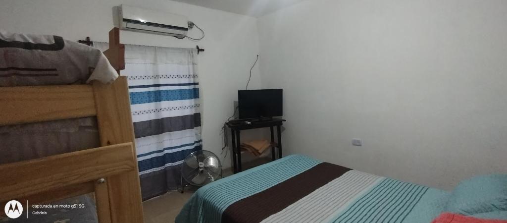 - une chambre avec un lit et une télévision dans l'établissement El CARACOL, à San Fernando del Valle de Catamarca