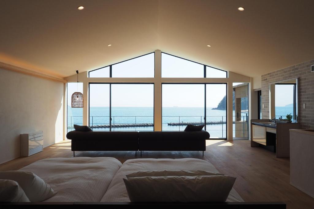 a bedroom with a couch and a view of the ocean at 小豆島の貸切宿　おぼろととろろ　【最大10名様】【一日一組限定】【瀬戸内オーシャンフロントのお宿】 in Shodoshima