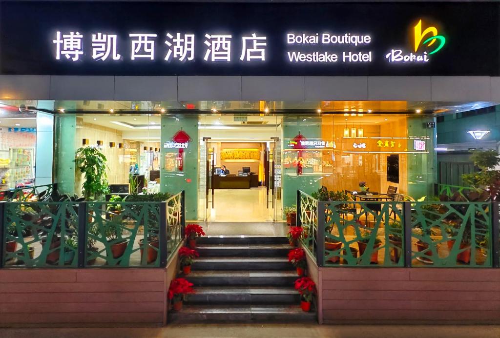 ein Gebäude mit einer Treppe vor einem Geschäft in der Unterkunft Hangzhou Bokai Westlake Hotel in Hangzhou