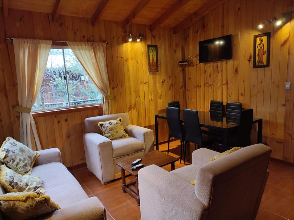 a living room with two couches and a dining room at cabaña de 1 piso in Coñaripe
