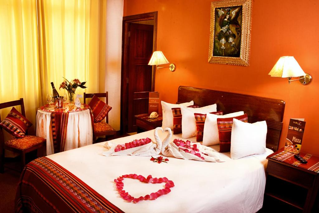 Un dormitorio con una cama con dos corazones. en IMPERIAL CUSCO HOTEL, en Cusco
