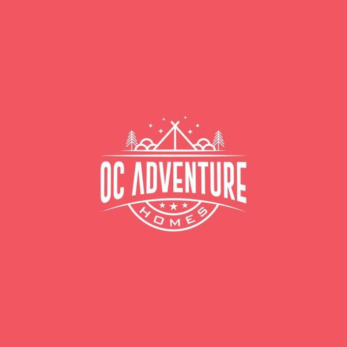 a red logo with a house and the words dc adventure homes at OC Adventure Homes in Stanton
