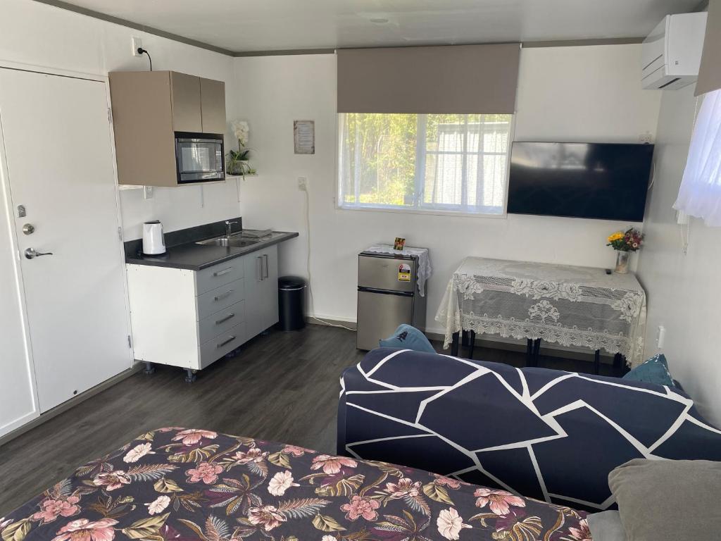 a room with a kitchen and a living room at Self Contained En-Suite Private Bathroom, Private Entrance, Close to Shops & Hospital Homestay in Hamilton