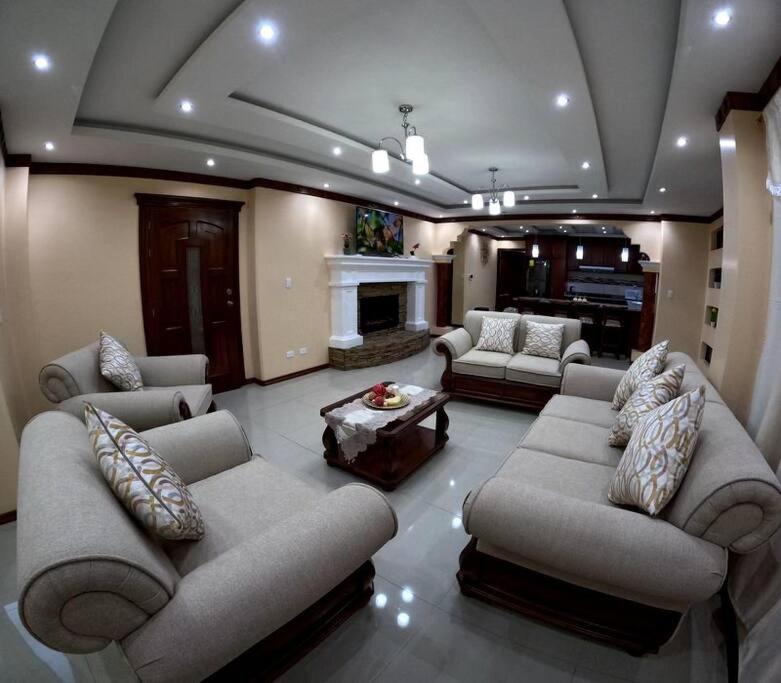 a large living room with couches and a fireplace at Your Home Away From Home ! in Ambato