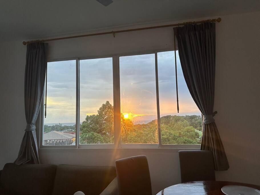 a window with a view of the sunset at 2 Bedroom Seaview Apartment Lanta Sport Resort 305 in Phra Ae beach