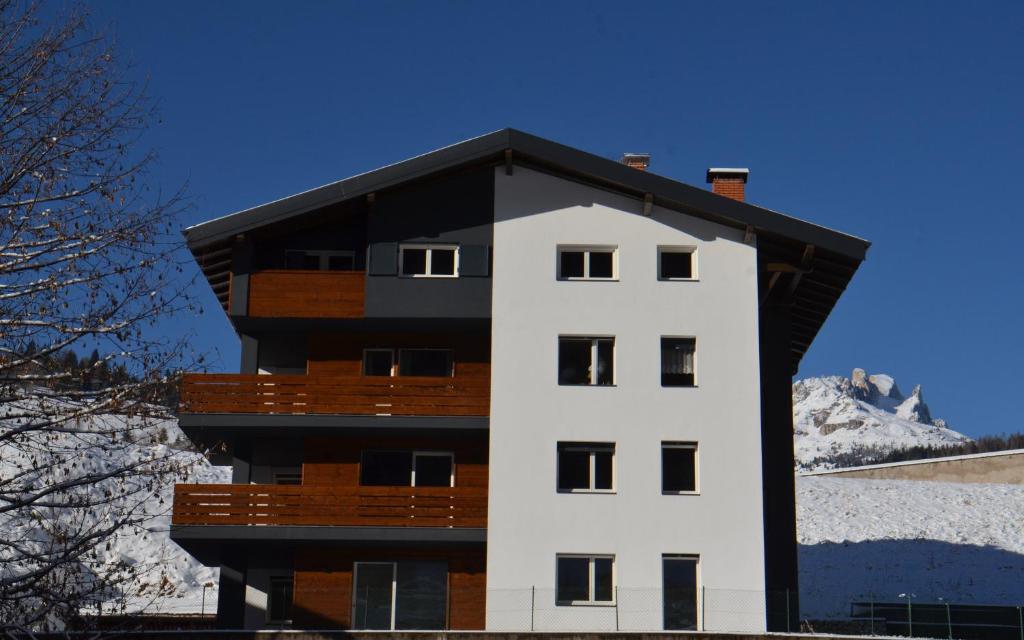 un edificio bianco con tetto nero di House Casa Defrancesco a Moena