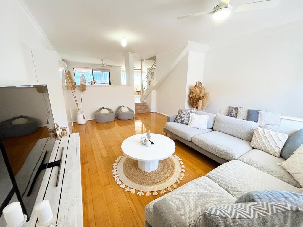 a living room with a couch and a table at The Scarborough Beach House - Walk to the beach! in Perth
