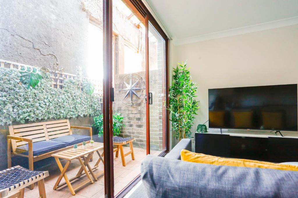 a living room with a couch and a tv at Cozy 2 Bedroom Apartment Chippendale II in Sydney