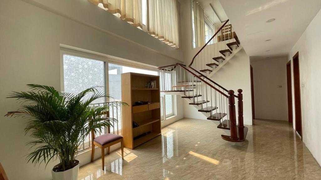 a hallway with a spiral staircase and a plant at Hồ Ba Mẫu Apartment LilyHome in Hanoi